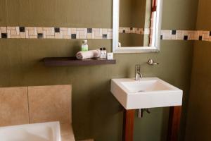 a bathroom with a sink and a mirror at Fourteen Tumbleweed, Cathkin Estates in Ardmore