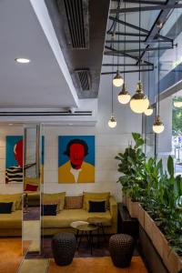 a lobby with couches and tables and paintings on the wall at Catalonia Diagonal Centro in Barcelona