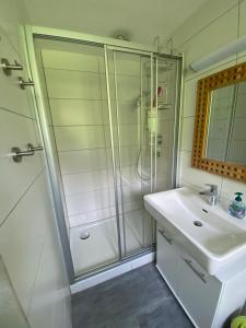 ein Bad mit einer Dusche und einem Waschbecken in der Unterkunft Family Appartment - Dachstein View in Ramsau am Dachstein