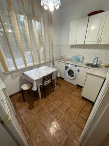 een keuken met een tafel en een wasmachine bij Apartment Seifullina473 in Alma-Ata