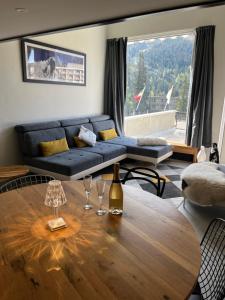 a living room with a blue couch and a wooden table at Flaine Forum H1 Cassiopée Mezzanine & Terrasse in Flaine