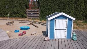 ein kleines, blaues Spielhaus auf einer Holzterrasse in der Unterkunft Ferienwohnung Gnitzer Auszeit in Lütow