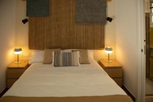 1 dormitorio con 1 cama blanca grande y 2 lámparas en HOTEL LOS ALAMOS BOUTIQUE, en Plasencia