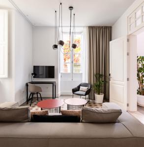 ein Wohnzimmer mit Couch und Tischen in der Unterkunft The Park Suites by IRES LAR in Santa Cruz de Tenerife