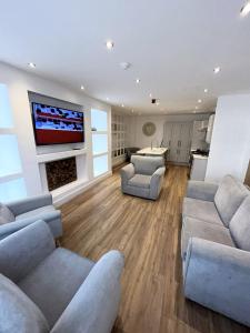 sala de estar con 2 sofás y TV de pantalla plana en Beach House By Sasco, en Blackpool