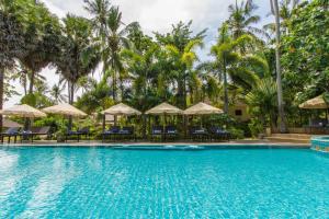 ein Pool in einem Resort mit Stühlen und Sonnenschirmen in der Unterkunft Anda Lanta Resort in Ko Lanta + 30 Fotos