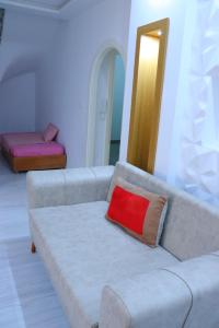 een woonkamer met een bank met een rood kussen bij séjournez auprès de toutes les commodités in Sousse
