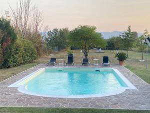 einen Pool mit Stühlen und einem Tisch in der Unterkunft Campagna Toscana - A casa di Vale in Pistoia