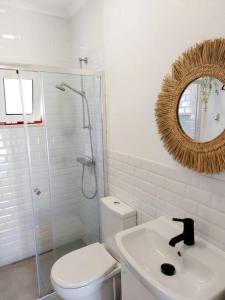 bagno con servizi igienici, lavandino e specchio di A Casa do Arez ad Alcácer do Sal