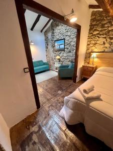 1 dormitorio con 2 camas y pared de piedra en Casa Rural Basiver - Habitación Braña de Los Tejos, en Armaño