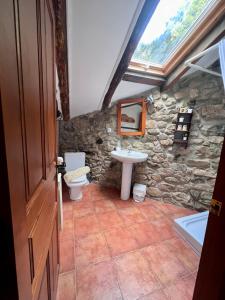 Baño de piedra con lavabo y aseo en Casa Rural Basiver - Habitación Braña de Los Tejos, en Armaño