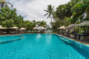 ein Pool in einem Resort mit Stühlen und Sonnenschirmen in der Unterkunft Anda Lanta Resort in Ko Lanta