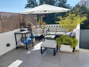 a patio with a table and an umbrella and plants at Green Charm House Lisbon in Lisbon