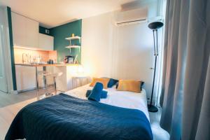 ein Schlafzimmer mit einem Bett mit einer blauen Decke in der Unterkunft L'Épicentre - Clim - Vu sur port- Terrasse -Plage TOP PROS SERVICES in La Grande-Motte