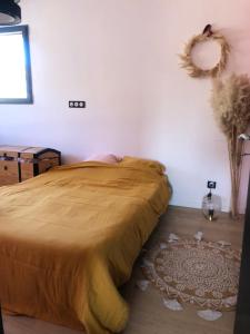 um quarto com uma cama com uma colcha castanha em Villa piscine 6 personnes em Meyzieu