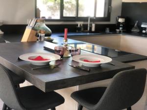 une table avec deux plaques blanches au-dessus dans l'établissement Villa piscine 6 personnes, à Meyzieu