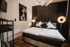a bedroom with a bed with black and white pillows at Boutique Hotel Cologne in Cologne