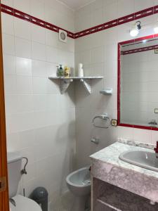 a bathroom with a sink and a toilet and a mirror at Villa Luz Deluxe in Mazagón +27 photos