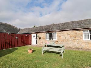 a bench in the yard of a stone house at Goldfinch in Grindon