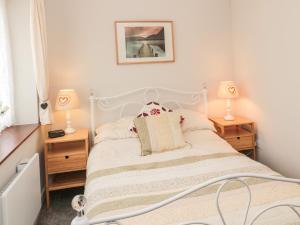 a bedroom with a bed with two night stands and two lamps at Goldfinch in Grindon