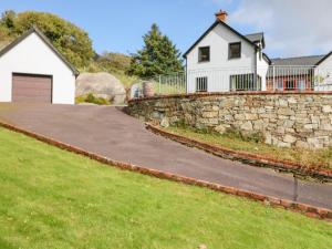 a driveway with a stone wall and a house at Ocean View in Adrigole