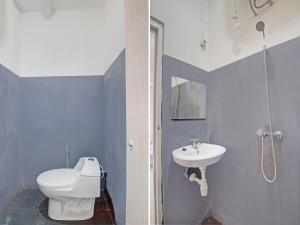 a bathroom with a toilet and a sink at OYO 92964 Kost 99 in Manado