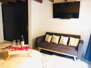 a living room with a couch and a table with wine glasses at Departamento centrico - Pikachos House - in Guanajuato
