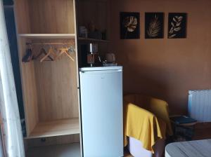 a white refrigerator in a room with a cabinet at Un petit coin de paradis in Orpierre