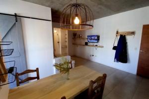 a dining room with a wooden table and a chandelier at Moderno dpto cercanías Puerto de Frutos! in Tigre
