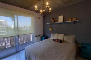 a bedroom with a white bed and a large window at Moderno dpto cercanías Puerto de Frutos! in Tigre