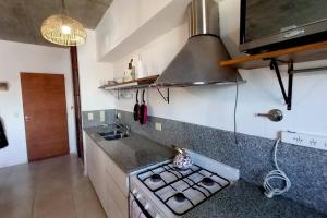 a kitchen with a stove and a counter top at Moderno dpto cercanías Puerto de Frutos! in Tigre