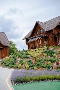 una casa di tronchi con un giardino di fronte di Смарагдовий пагорб a Plavie