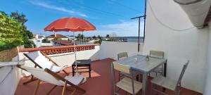 - un balcon avec une table, des chaises et un parasol dans l'établissement Casa Lavradores, Torrao, à Torrão