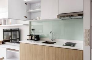 een keuken met witte kasten en een wastafel bij The Luxe Loft 2Bedroom Apartment in Singapore! in Singapore