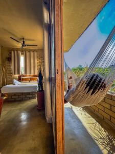 a hammock in a room with a view of a bedroom at Villa Macarena Apartamentos Boutique - Adults Only in Puerto Escondido