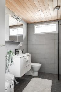 a bathroom with a white sink and a toilet at Moderni paritalo lähellä lentokenttää, free parking, sauna in Vantaa