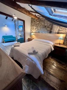 a bedroom with a large bed and a stone wall at Casa Rural Basiver - Habitación Braña de Los Tejos in Armaño