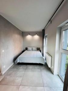 a bedroom with a bed and a large window at Property Apart – Legnicka Business Center in Wrocław