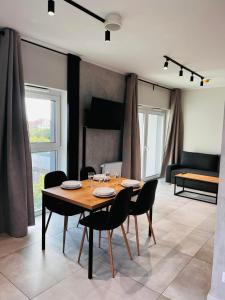 a dining room with a wooden table and chairs at Property Apart – Legnicka Business Center in Wrocław