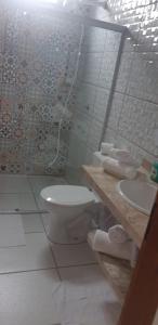 a bathroom with a toilet and a sink at Casa Flor in Antônio Cipriano