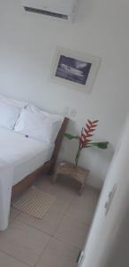 1 dormitorio con 1 cama y planta en el suelo en Casa Flor en Antônio Cipriano