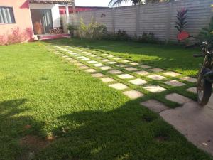 un jardín con un camino de piedra en el césped en Casa Flor en Antônio Cipriano