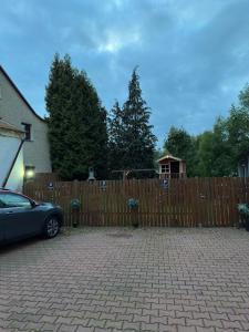 a car parked in front of a wooden fence at Moderní byt v centru města in Liberec