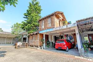 a red car parked in front of a house at SPOT ON 93006 Waithozz Bunkbeds in Yogyakarta