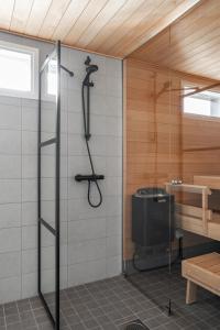 a shower in a bathroom with a glass door at Moderni paritalo lähellä lentokenttää, free parking, sauna in Vantaa