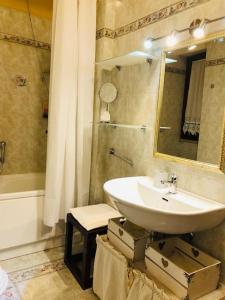 uma casa de banho com um lavatório, um espelho e uma banheira em La terrazza sul bosco em Sassari