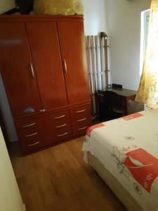 a bedroom with a bed and a large wooden dresser at Hostel Sancris in São José dos Campos