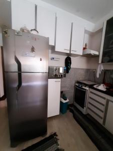 a kitchen with a stainless steel refrigerator and a stove at Hostel Sancris in São José dos Campos