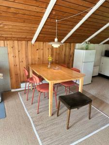einen Holztisch und Stühle in einem Zimmer mit Kühlschrank in der Unterkunft Vacation House In Arrild Ferieby in Toftlund