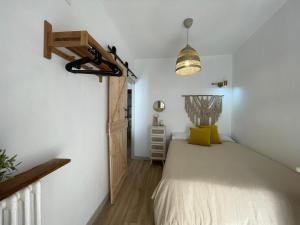 1 dormitorio con 1 cama y luz colgante en Casa Mariete en Villanúa